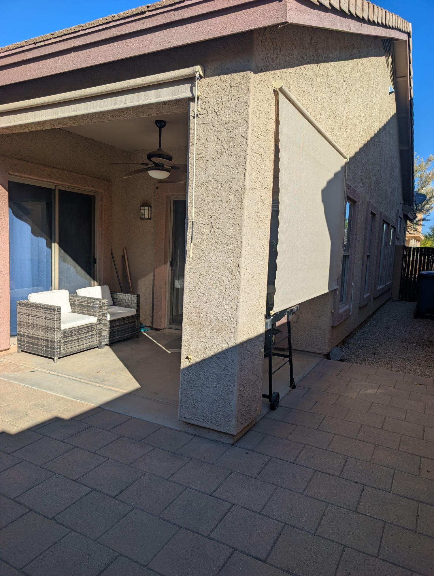 Covered patio with ceiling fan and roll-down sun shades